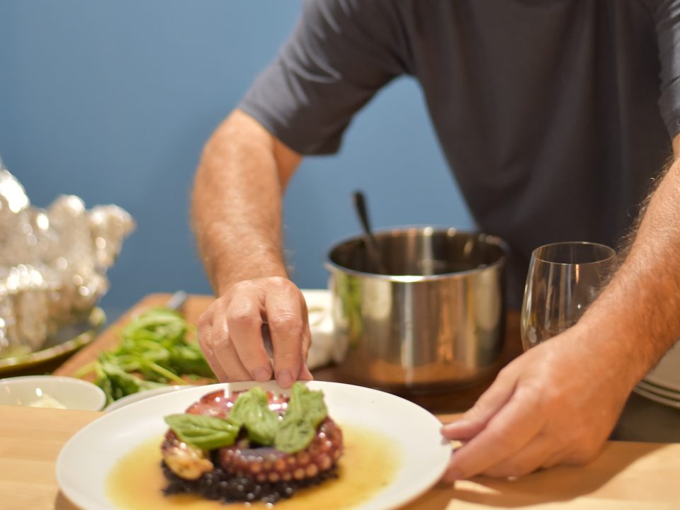 Chef adding fresh basil garnish